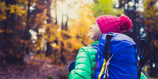 a woman hiking through the fall foliage